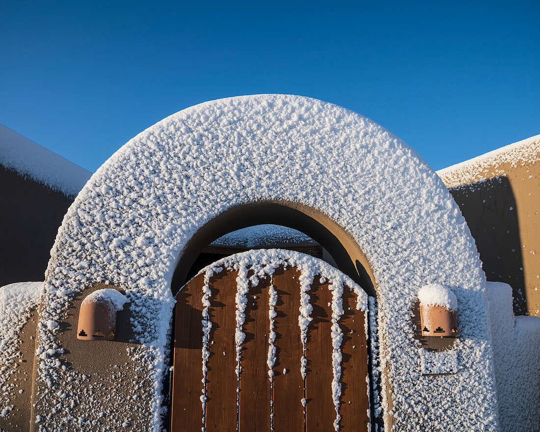 Usa, New Mexico, Santa Fe, Tor zum Haus im Adobe-Stil im Winter mit Schnee bedeckt