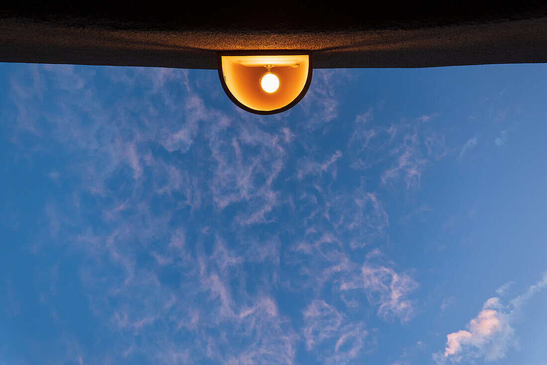 Low angle view of outdoor lamp on building against blue sky