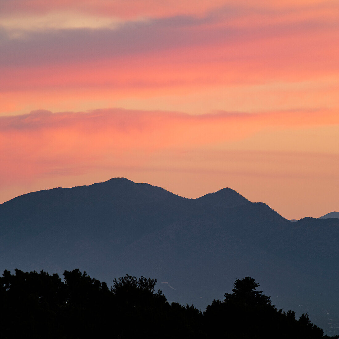USA, New Mexico, Sandia Mountains von Santa Fe, farbenfroher Himmel über den Sandai Mountains bei Sonnenuntergang