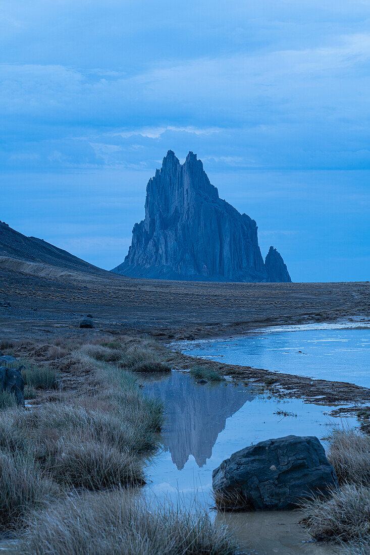 USA, New Mexico, Desert landscape with Ship Rock after monsoon rain at dusk