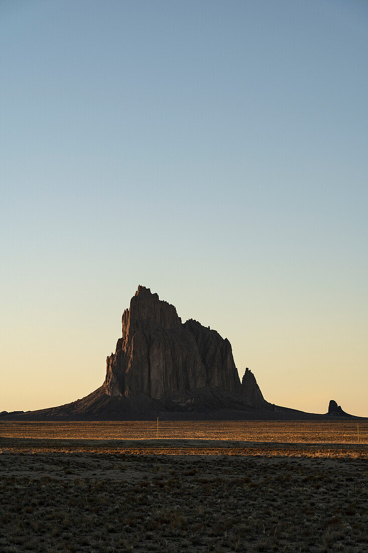 USA, New Mexico, Wüstenlandschaft mit Ship Rock bei Sonnenuntergang