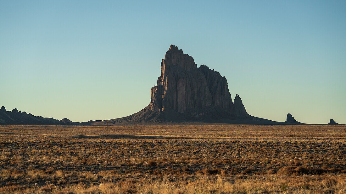 USA, New Mexico, Wüstenlandschaft mit Ship Rock bei Sonnenuntergang