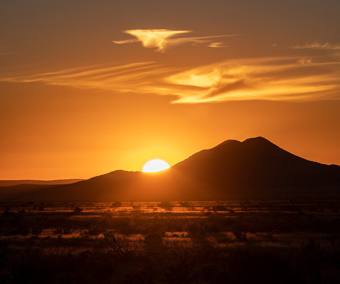 USA, New Mexico, Santa Fe, Sun setting above hill in Cerrillos Hills State Park