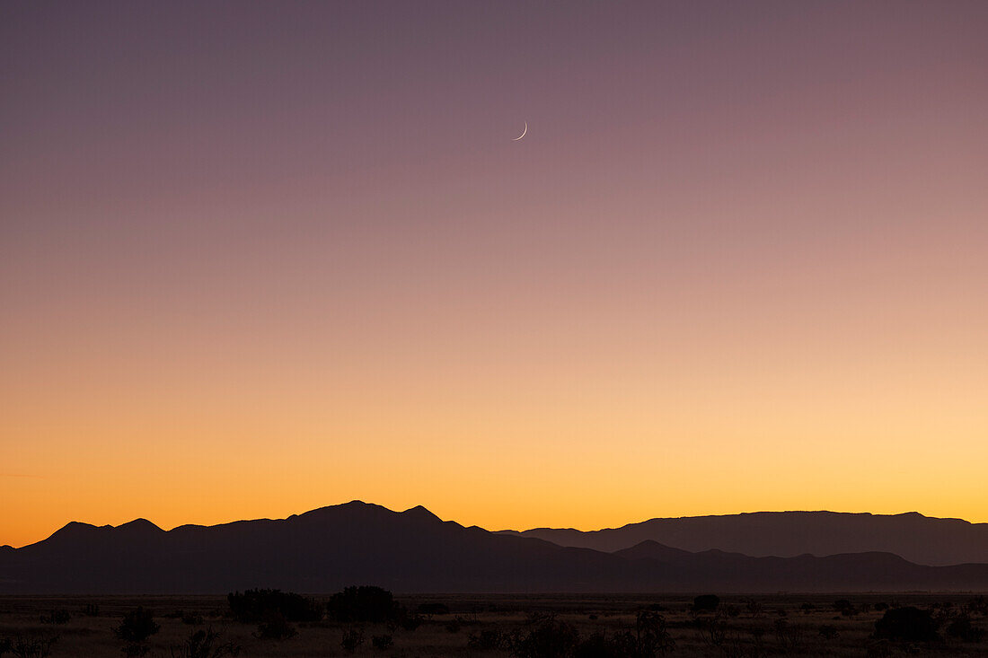 USA, New Mexico, Santa Fe, Crescent moon above Jemez Mountains at sunset