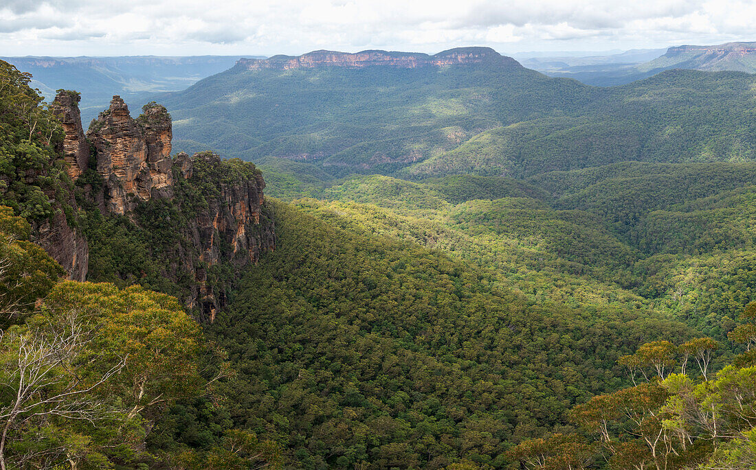 Australia, New South Wales, Three Sisters rock formation with Mount Solitary and Jamison Valley in Blue Mountains National Park seen from Echo Point Lookout