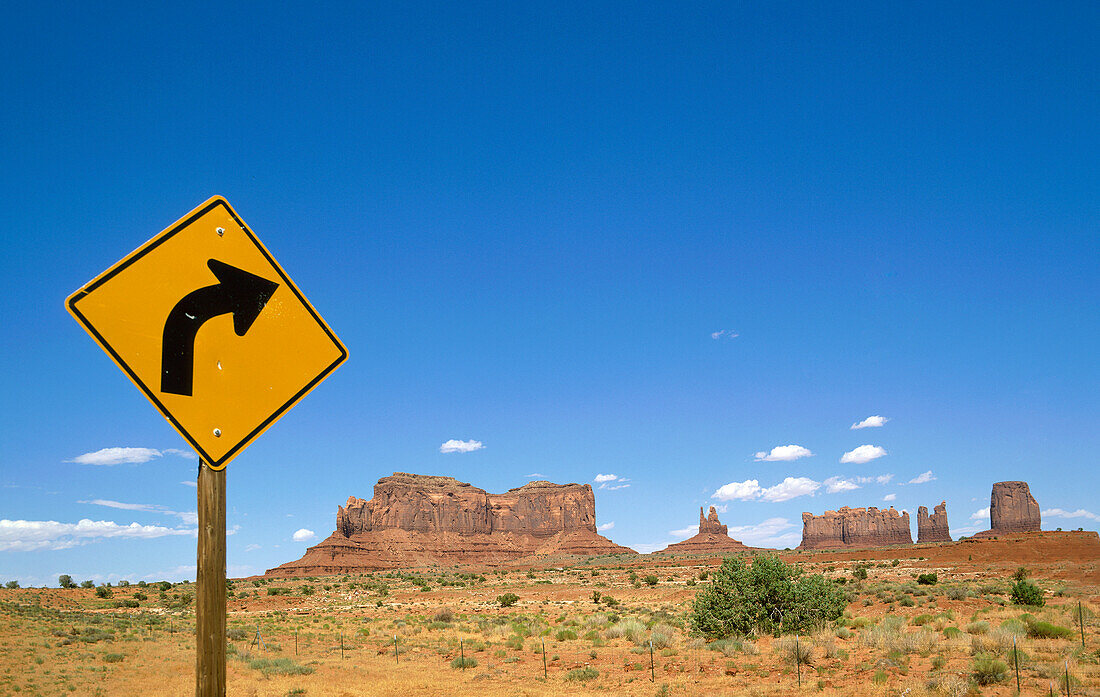 Arizona, Monument Valley Tribal Park, Road sign in Monument Valley with West and East Mitten Buttes in background