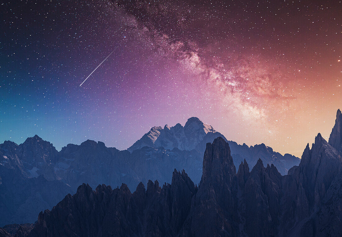 Italy, Veneto, Cortina d'Ampezzo, Dolomites, Milky way and falling star over rocky mountains