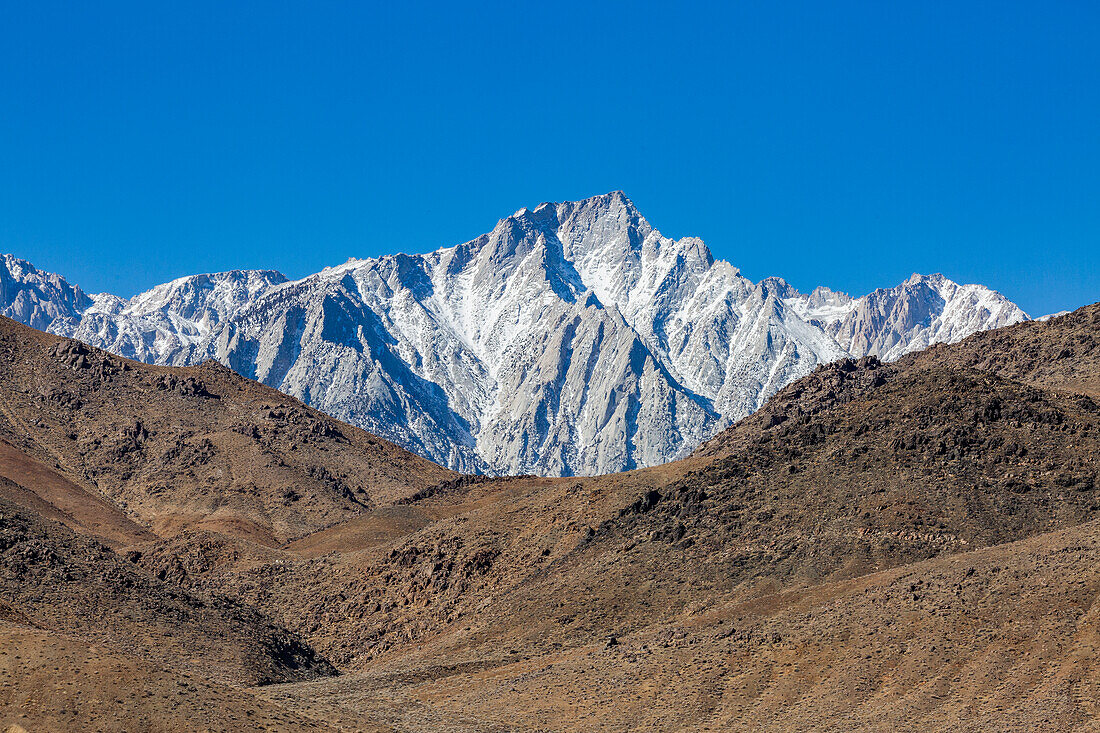 USA, California, Lone Pine, Snowcapped Mount Whitney with rocky hills in foreground