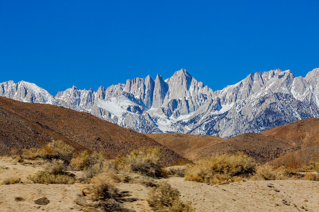 USA, California, Lone Pine, Snowcapped Mount Whitney with rocky hills in foreground