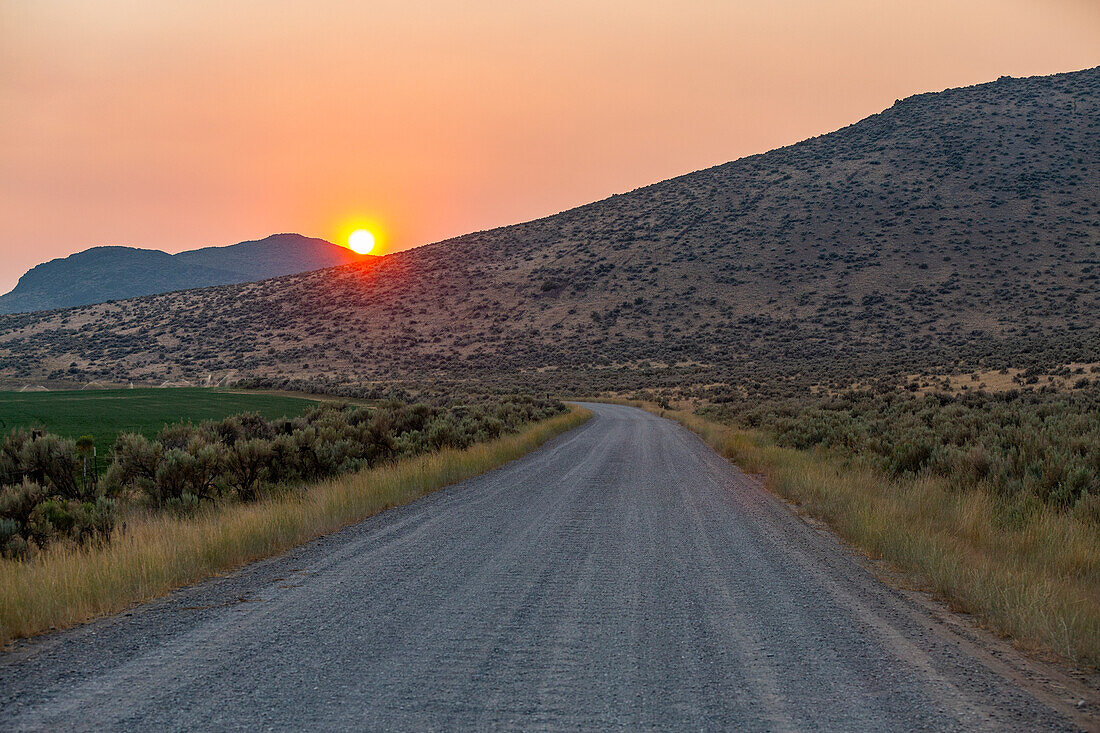 USA, Idaho, Bellevue, Feldweg und Hügel bei Sonnenuntergang