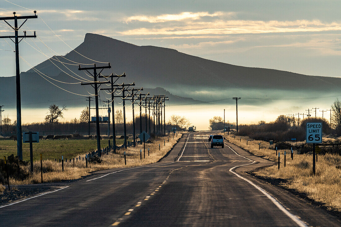 USA, Idaho, Bellevue, Landstraße mit Berg- und Morgennebel in Ferne