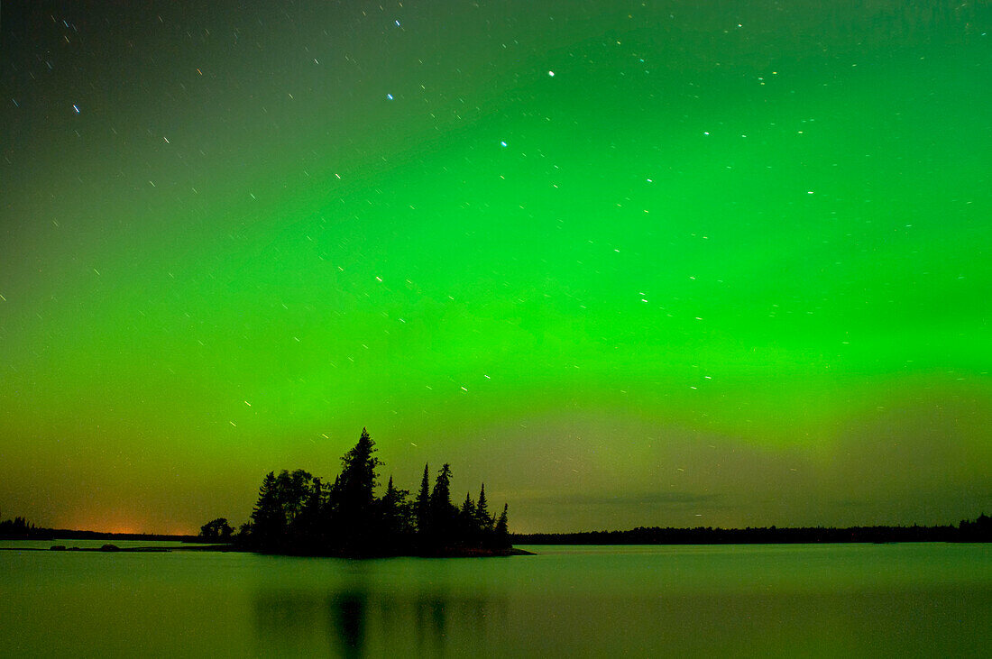 Canada, Manitoba, Whiteshell Provincial Park. Aurora borealis reflects on lake