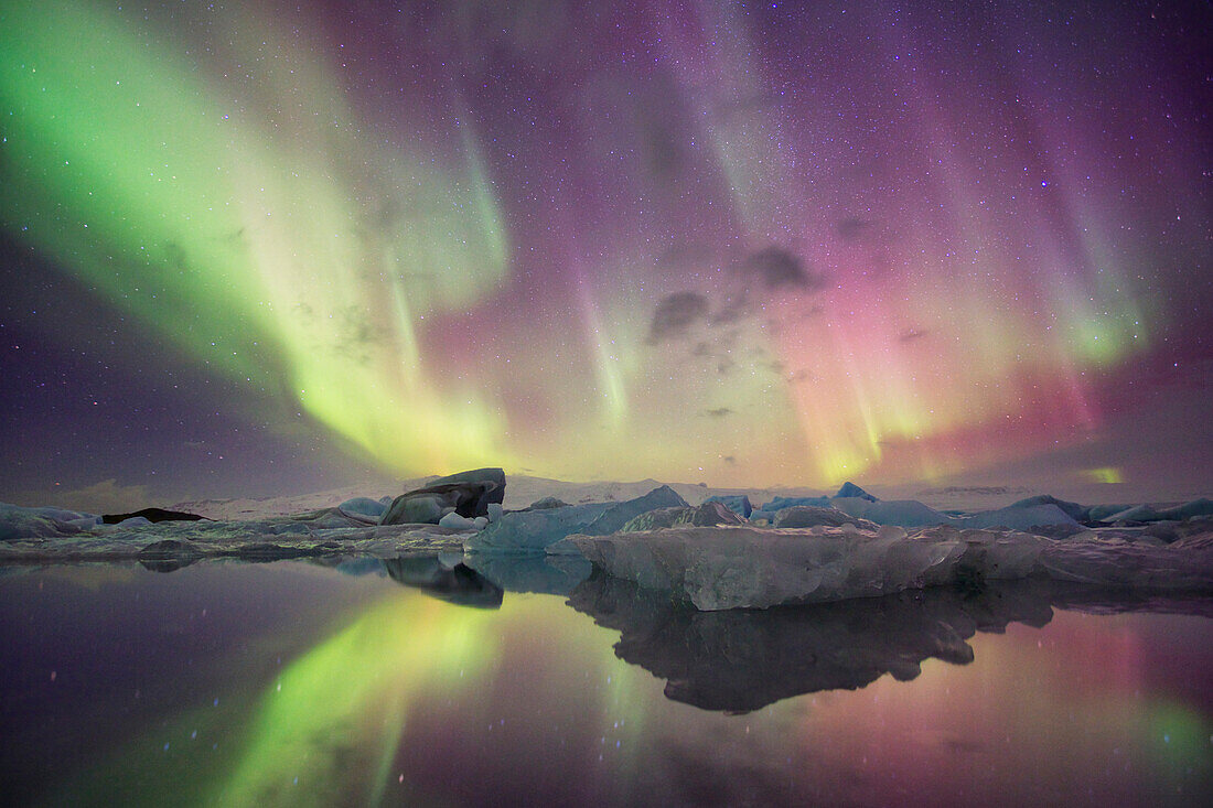 Island, Jökulsárlón. Auroralichter spiegeln sich in der Lagune wider