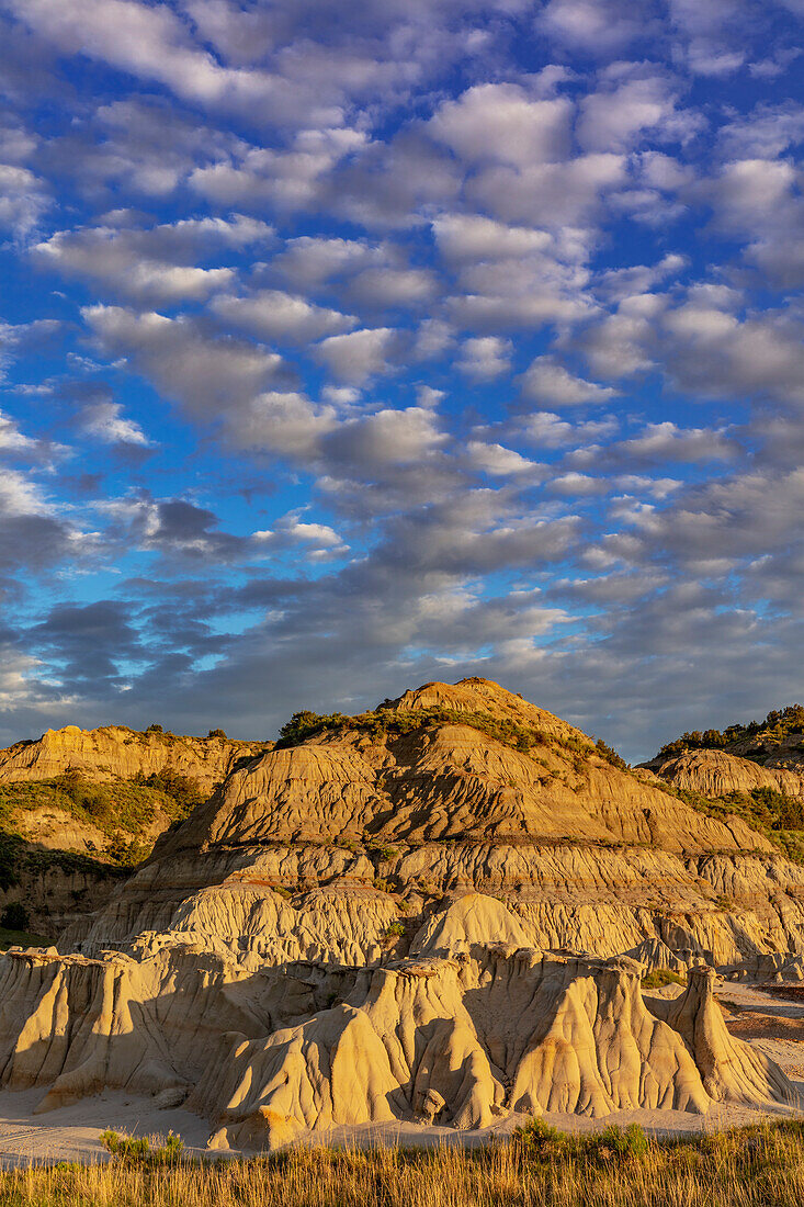 Dramatische Sonnenaufgangswolken über Ödlandformationen im Theodore-Roosevelt-Nationalpark, North Dakota, USA.