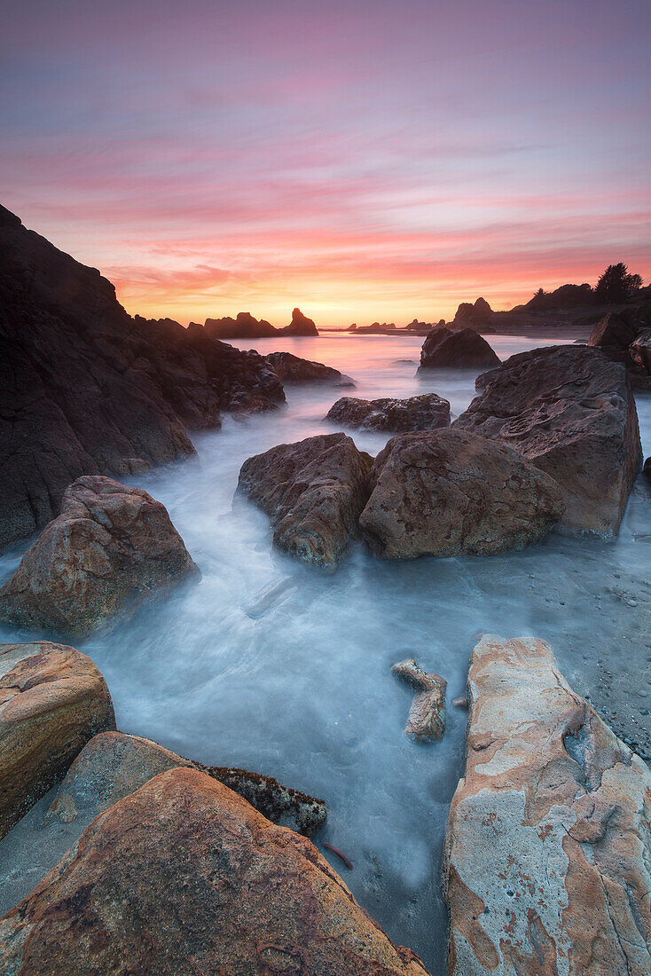 Usa, Oregon. Sunset and incoming tide at Harris Beach State Park. Rocks at arch.