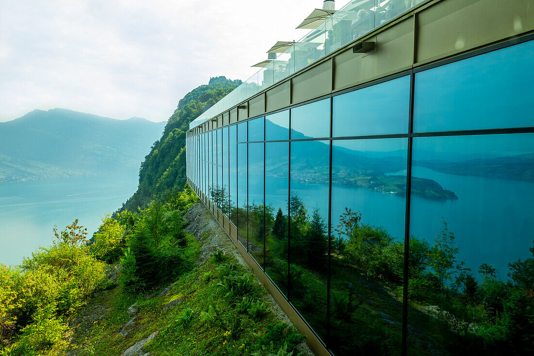 Hotel Five Stars Bürgenstock with Glass wall with reflection over Lake Lucerne and Mountain in Sunny Day in Bürgenstock, Nidwalden, Switzerland.