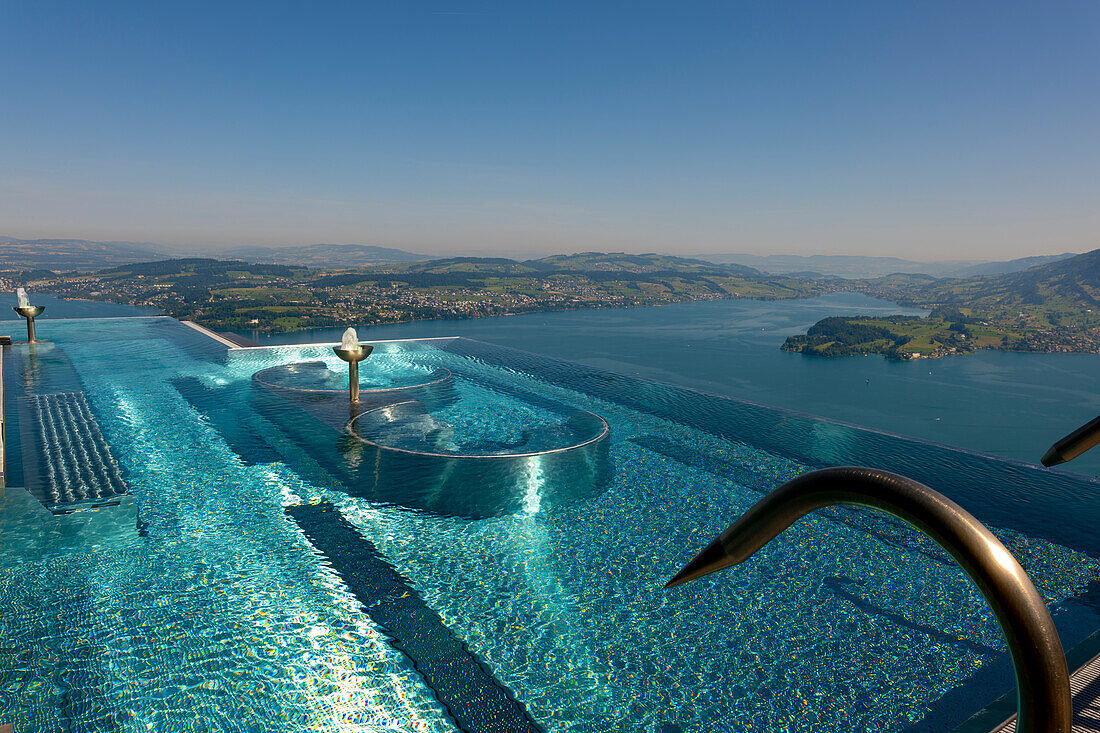 Infinity Swimming pool and View over Mountain and Lake and City of Lucerne in a Sunny Summer Day From Burgenstock, Nidwalden, Switzerland.