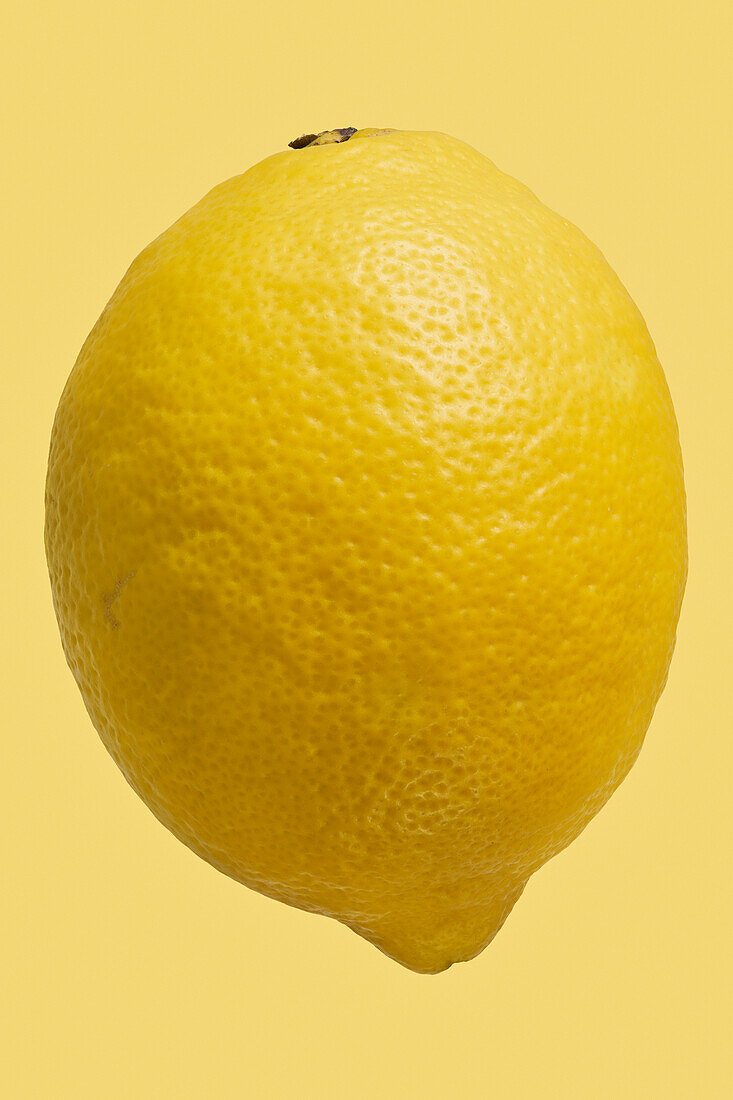 Nahaufnahme einer leuchtenden, ganzen gelben Zitrone