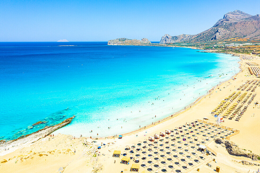 Beach umbrellas and sunbeds on white sand of Falassarna beach overlooking the crystal sea, Kissamos, Chania, Crete, Greek Islands, Greece, Europe