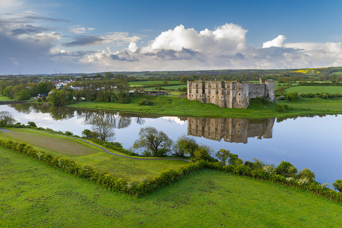 Carew Castle spiegelt sich im Mühlenteich an einem ruhigen Frühlingsmorgen wider, Pembrokeshire Coast National Park, Wales, Vereinigtes Königreich, Europa