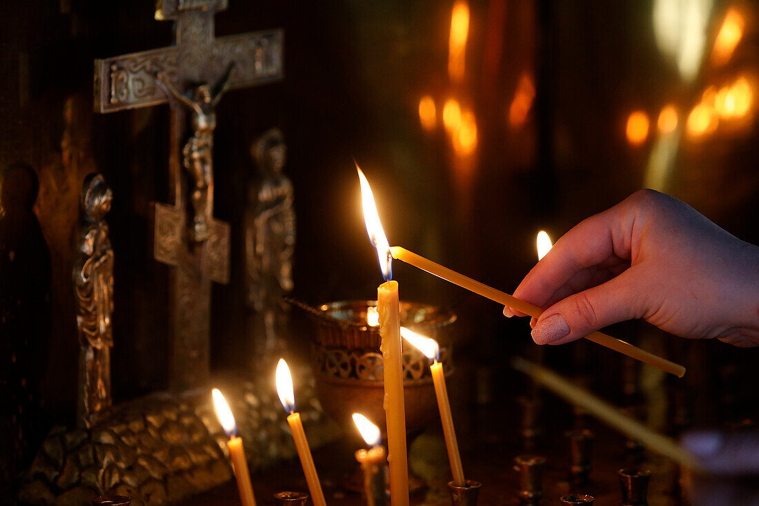 Faithful lighting a candle in Saint Teaodor Tiron (Ciuflea) Cathedral and Monastery, Chisinau, Moldova, Europe