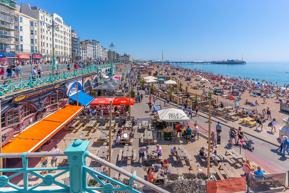 Blick auf Strand, Café am Meer und Brighton Palace Pier an einem sonnigen Tag, Brighton, East Sussex, England, Vereinigtes Königreich, Europa