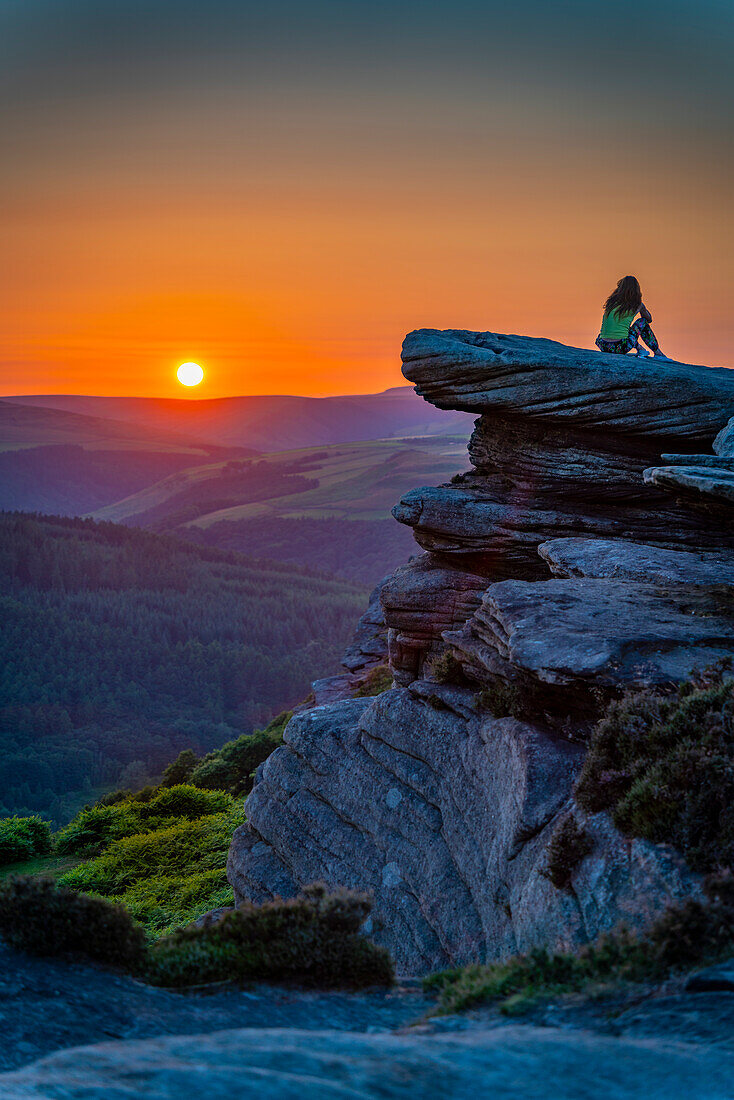 View of young woman on Bamford Edge at sunset, Bamford, Peak District National Park, Derbyshire, England, United Kingdom, Europe