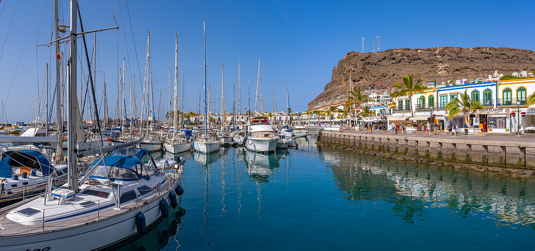 Blick auf Boote und farbenfrohe Gebäude entlang der Promenade in der Altstadt, Puerto de Mogan, Gran Canaria, Kanarische Inseln, Spanien, Atlantik, Europa