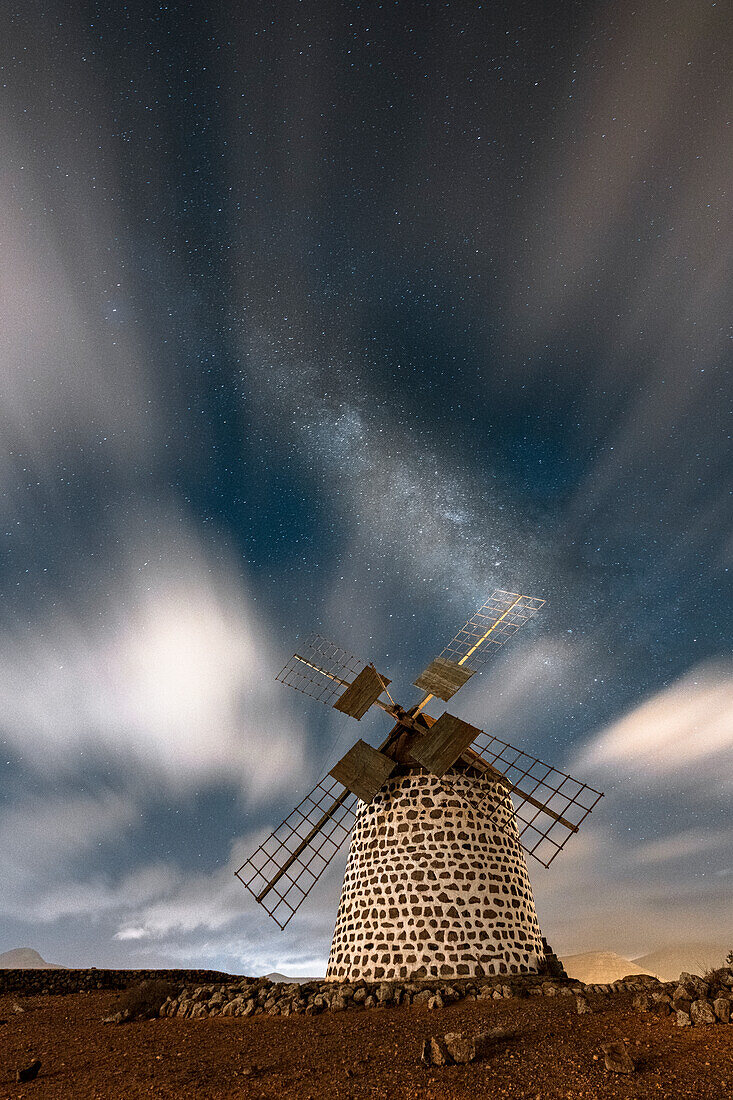 Langzeitbelichtung von Wolken am Nachthimmel über der alten Windmühle, La Oliva, Fuerteventura, Kanarische Inseln, Spanien, Atlantik, Europa