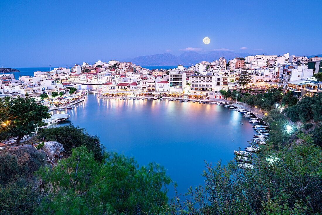 Mondschein über der Altstadt von Agios Nikolaos und See in der Abenddämmerung, Präfektur Lasithi, Kreta, griechische Inseln, Griechenland, Europa