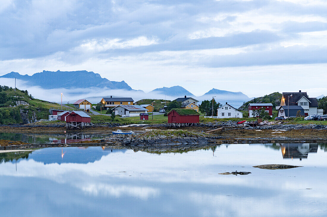Abenddämmerung über den roten Hütten der Fischer am arktischen Meer, Sommaroy, Tromso, Troms County, Nordnorwegen, Skandinavien, Europa