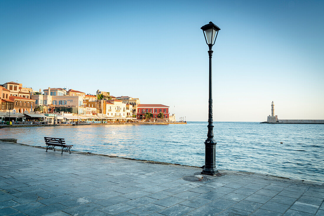 Alte Laterne im venezianischen Hafen von Chania mit Leuchtturm im Hintergrund, Kreta, griechische Inseln, Griechenland, Europa