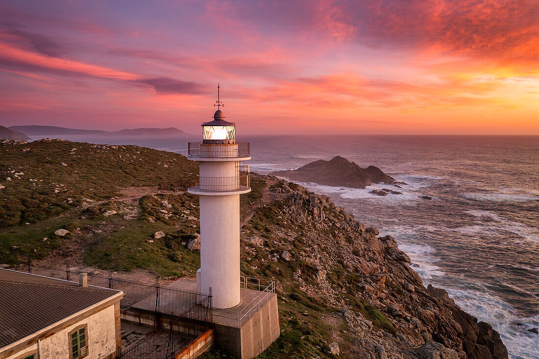 Luftaufnahme der Meereslandschaft von Cape Tourinan Lighthouse bei Sonnenuntergang mit rosa Wolken, Galicien, Spanien, Europa