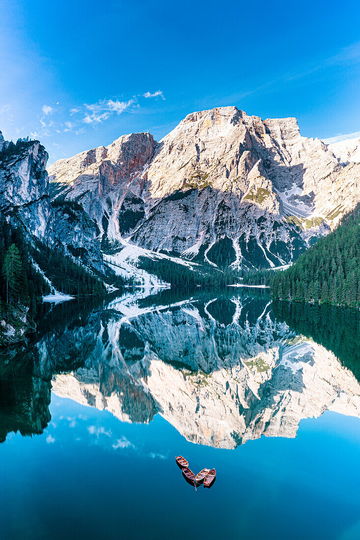 Lake Braies (Pragser Wildsee) with Croda del Becco reflected in water at dawn, aerial view, Dolomites, South Tyrol, Italy, Europe
