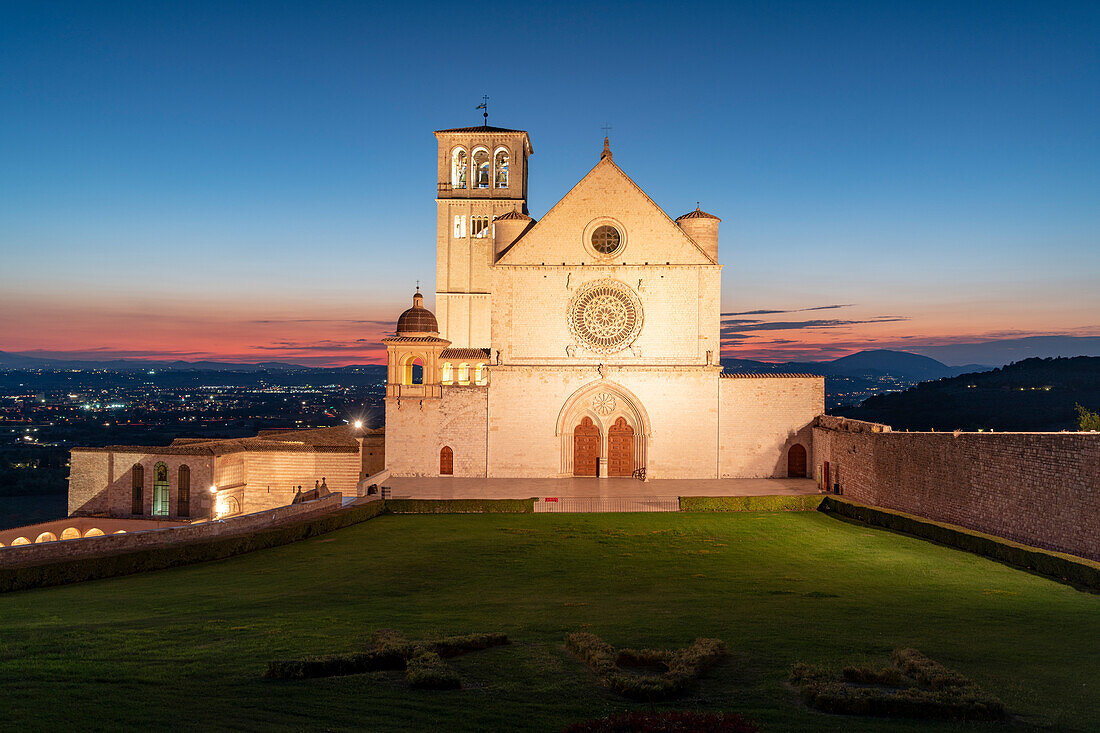 Facade of Basilica di San Francesco d'Assisi, UNESCO World Heritage Site, and gardens at dusk, Assisi, Perugia province, Umbria, Italy, Europe