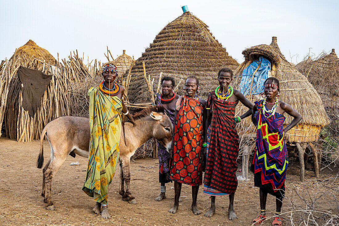 Frauen mit einem Esel vor ihrer Hütte, Jiye-Stamm, Bundesstaat Eastern Equatoria, Südsudan, Afrika