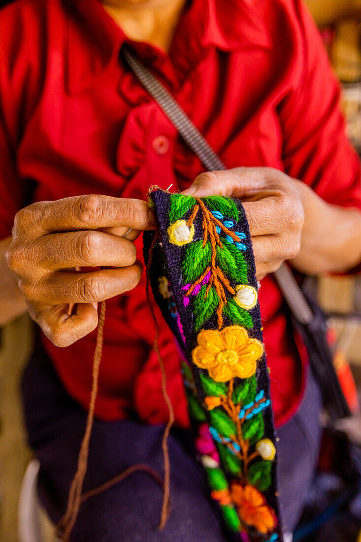 Woman embroidering traditional Alpaca wool hat band, Ayacucho, Peru, South America