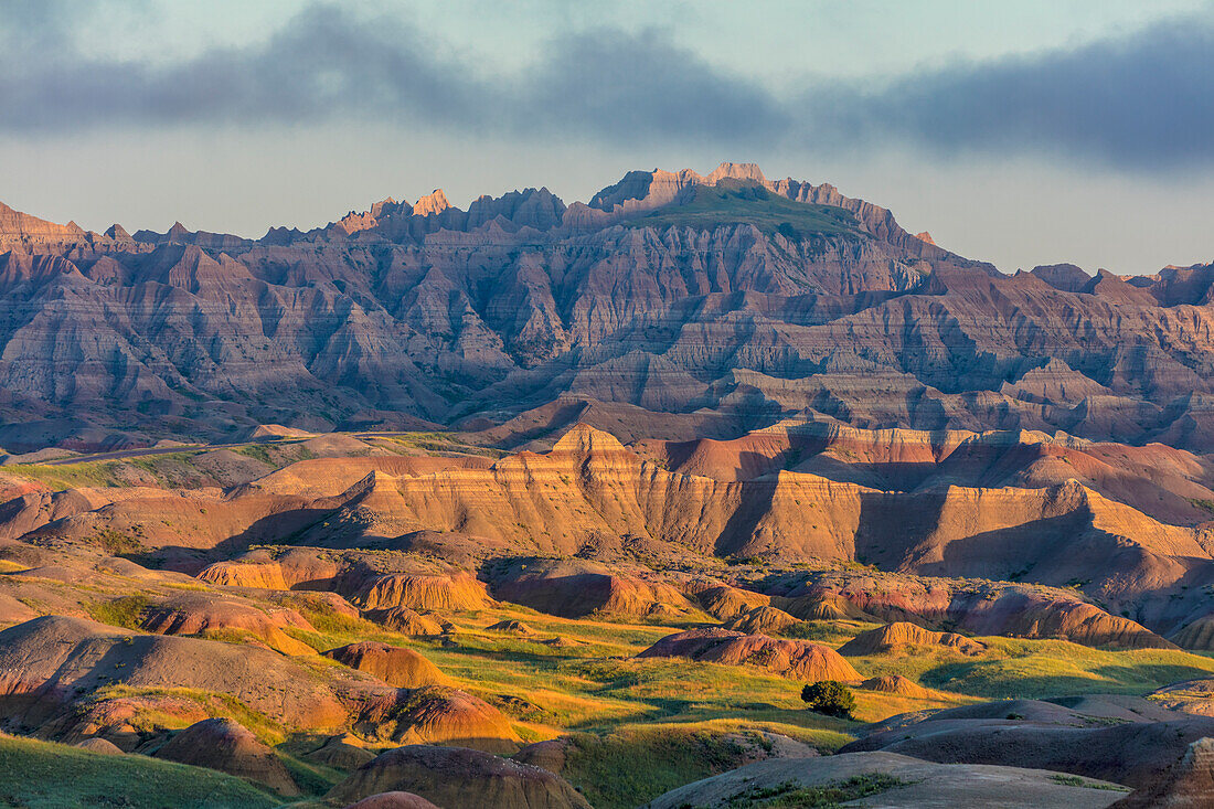 Sunrise light breaks through on a foggy morning in Badlands National Park, South Dakota, USA