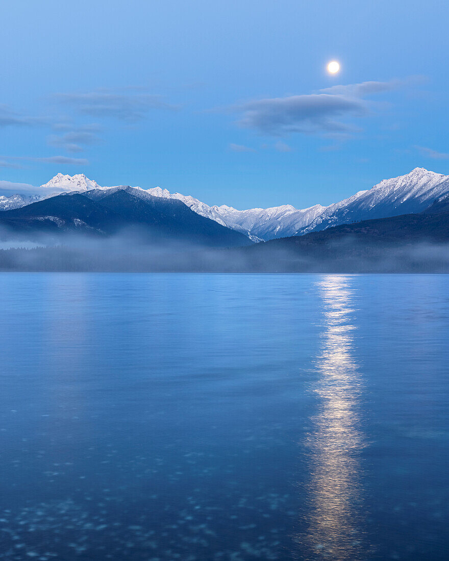 USA, Washington State, Seabeck. Moon setting over the Olympic Mountains and Hood Canal.