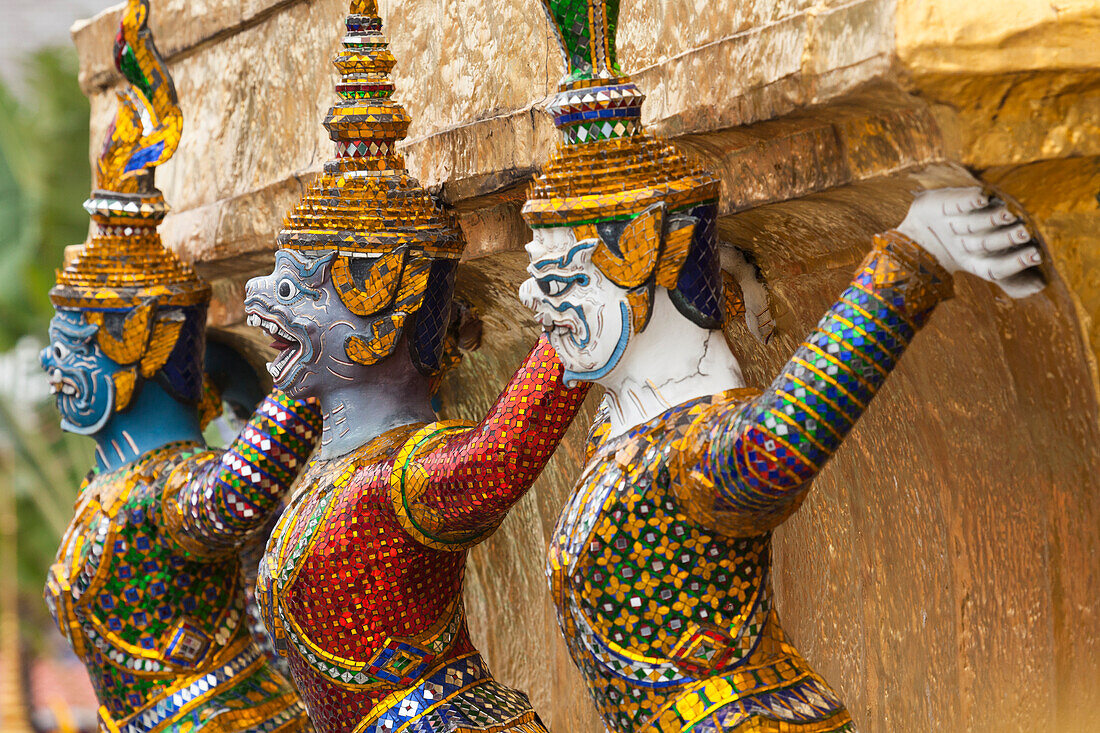 Thailand, Bangkok, Königspalast. Yaksha (Dämonen) bewachen einen der goldenen Chedi im Wat Phra Kaew.