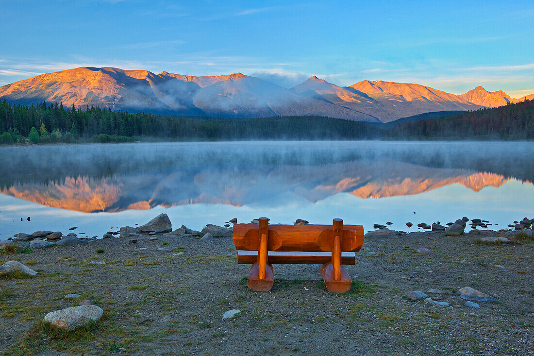 Canada, Alberta, Jasper National Park. Bench overlooking lake and mountains at sunset.
