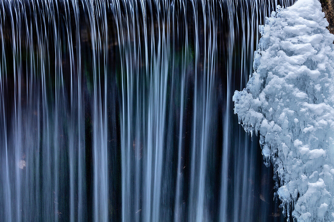 Water flowes by ice formation along Falls Creek in winter near Nelson, British Columbia, Canada