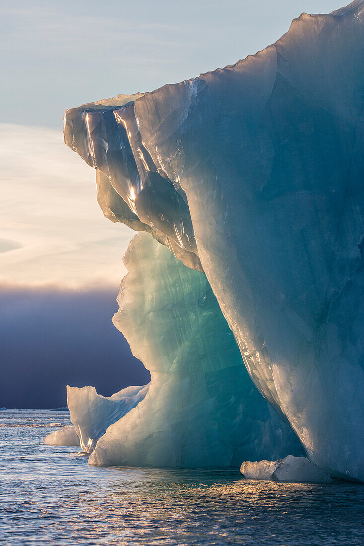 Norway, Svalbard, Kvitoya. Iceberg and fog bank at sunrise.