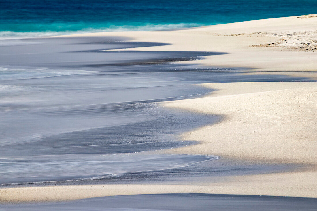 Brandungsmuster, das an den weißen Sandstrand gespült wird, Insel Espanola, Galapagos-Inseln, Ecuador.
