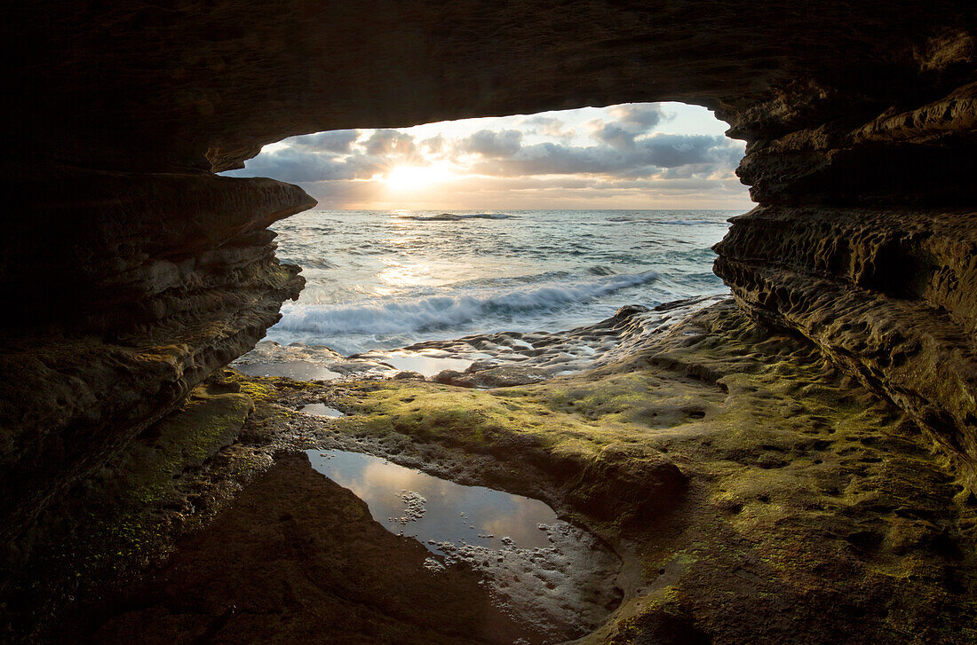 USA, California, La Jolla. Sunset though a sea cave.