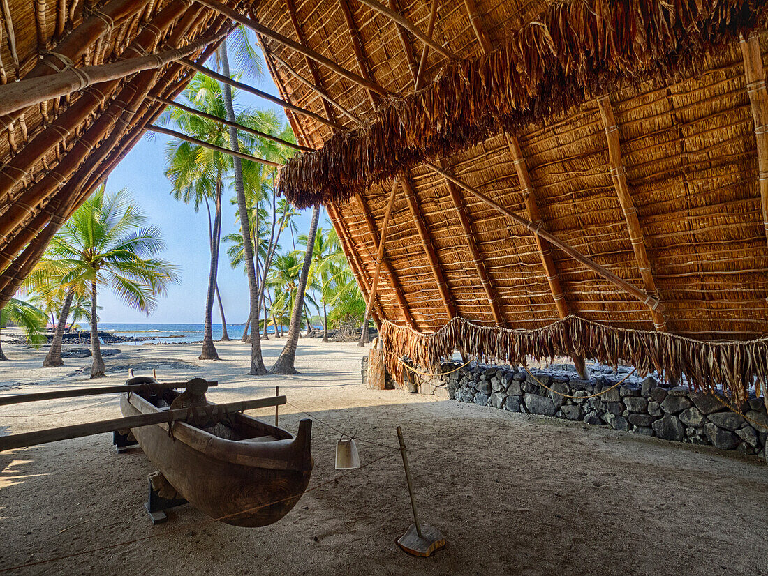 USA, Hawaii, Big Island.Canoe on display inside the Halau thatched A-frame structure at the National Historic Park Pu'uhonua o Honaunau.