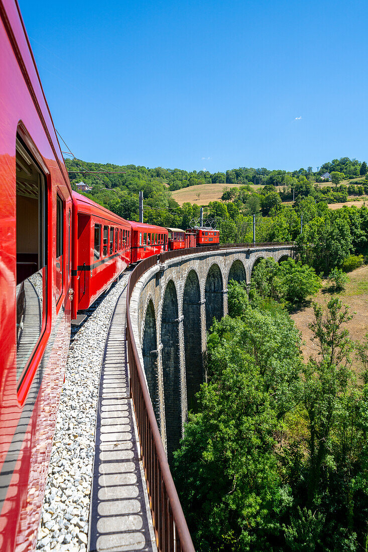 Petit Train de La Mure passes over an arched bridge, Isere, France