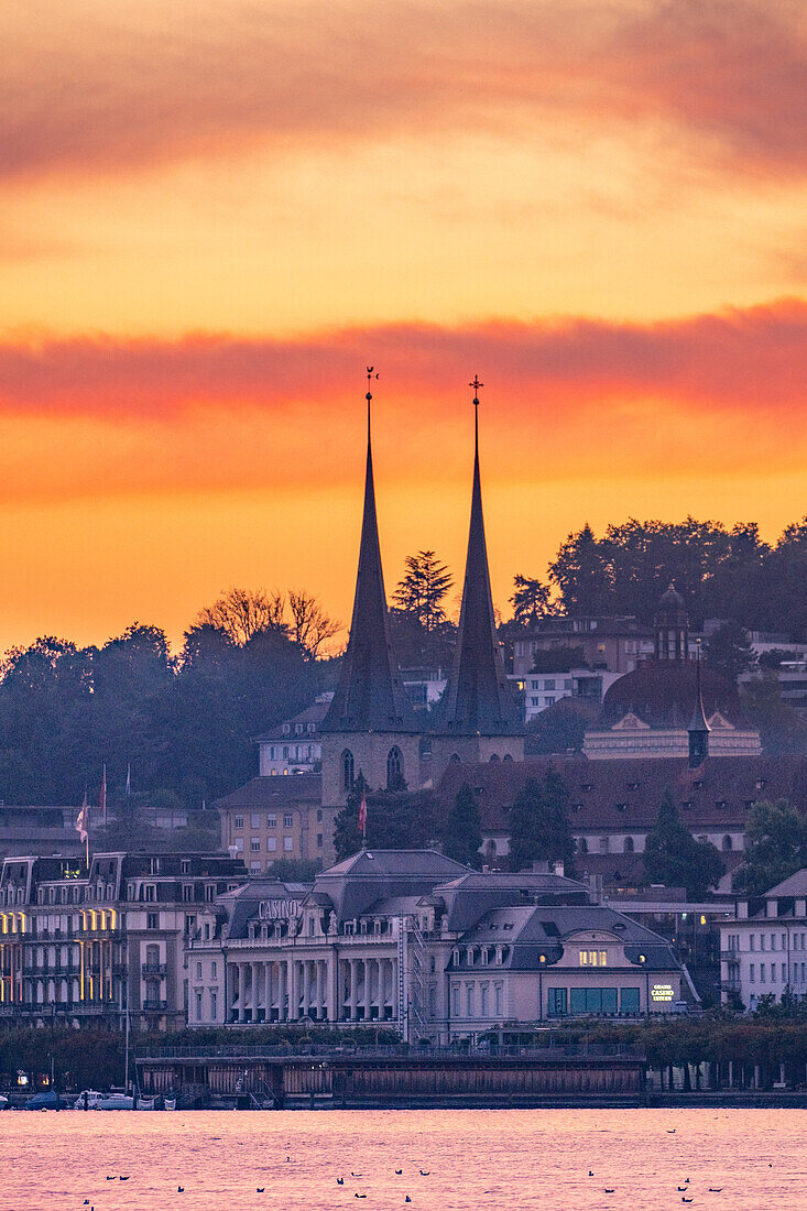 View over Lake Lucerne to Lucerne and the Hofkirche with a red sky