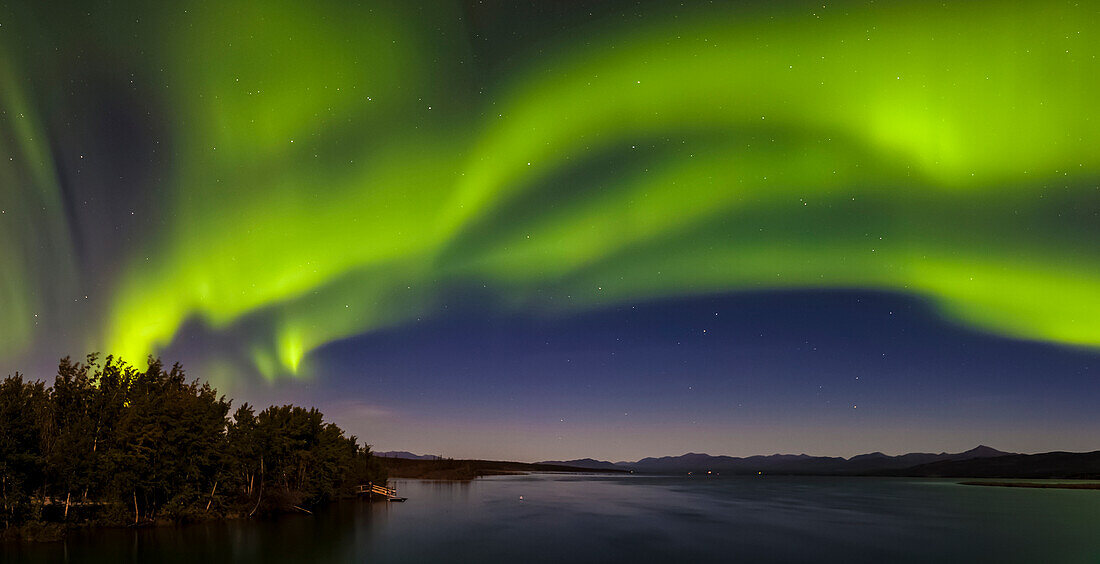 Kanada, Yukon. Nordlichter spiegeln sich im Marsh Lake bei Tagish wider.