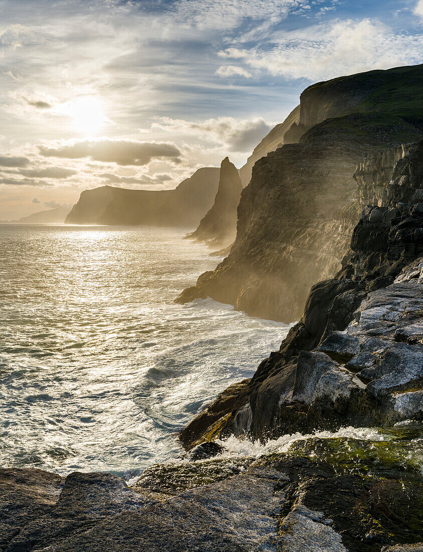 Die Westküste in der Nähe von Traelanipa mit Wasserfall Bosdalafossur bei Sonnenuntergang. Insel Vagar, Teil der Färöer-Inseln im Nordatlantik. Dänemark